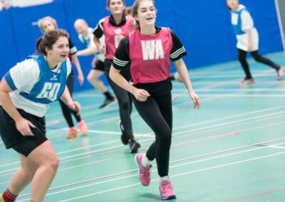 A group of children play netball in the sports hall at Club Cheadle Hulme.